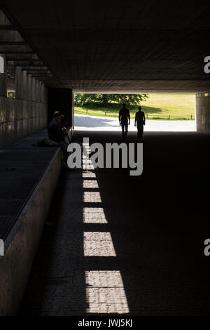 Ein strassenmusikant spielt Sax in den Schatten einer fußgängerunterführung zwischen den Englischen Garten, englischer Garten, und der Dichter Garten, München, Bayern, Ge Stockfoto