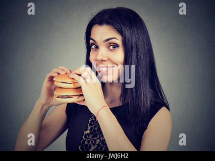 Fast Food ist mein Favorit. Frau essen einen Doppelten Cheeseburger genießen Sie den Geschmack Stockfoto