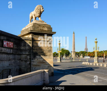 Einer der beiden Marmor Löwen auf den Jardin des Tuileries überragt die Place de la Concorde in Paris, mit dem Obelisk von Luxor und seine Rostrasäulen und Th Stockfoto