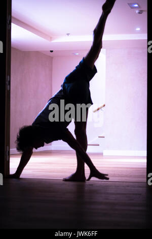 Männliche Yogalehrer Handstand Inversion Alisthenics und Yoga Asana Praxis im Fitness-Studio Fitness Pilates-Studio. Stockfoto