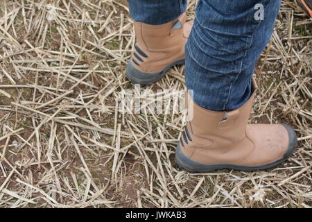 Nicht nach unten schauen. Mann in Jeans und rigger Schuhe stehen auf Stroh geschnitten. Stockfoto