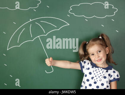 Kind Regenschirm in der Nähe der Schule Blackboard, Wetter Konzept Stockfoto