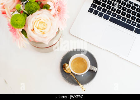 Feminine Workplace Konzept in Flach Stil mit Laptop, Kaffee, Blumen auf weißem Hintergrund. Ansicht von oben, hell, rosa und gold Stockfoto