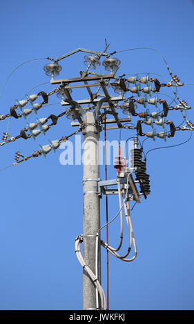 Industrielle Trennschalter und Schalter von einer hohen Spannung elektrische Leitung auf einen konkreten Pol und Hintergrund des blauen Himmels Stockfoto