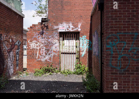 Verlassene Gebäude, Verfällt, Verlassen, Ziegel Außen, Graffiti, Schutt, Unkraut, Abgedichtet, Eisentor, Heruntergekommen, Gesichert, Kein Eintrag, Verworfen, Schreiben Stockfoto