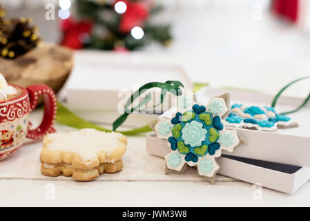 Weihnachtsplätzchen in Schneeflocken und goldenen Kegel geformt. Heiße Schokolade mit Marshmallows Süßigkeiten. Weiß Holz- Hintergrund Stockfoto