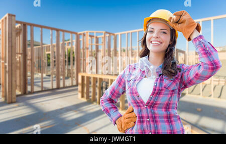 Jungen attraktiven weiblichen Bauarbeiter Handschuhe, Schutzhelm und Schutzbrille auf der Baustelle. Stockfoto