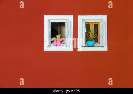 Bunte rote Fassade mit zwei Fenstern Stockfoto