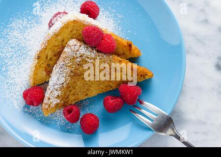 Die beiden Hälften des Brot Scheibe gebraten in French Toast, mit Himbeeren und Zucker Stockfoto