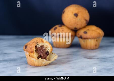 Die Hälfte gegessen Vanille Muffins mit Kakao und Schokolade auf Marmor Oberfläche Stockfoto