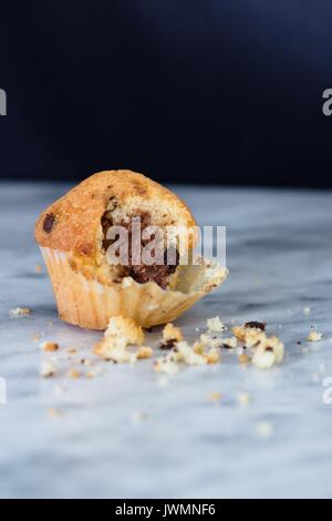 Die Hälfte gegessen Vanille Muffins mit Kakao und Schokolade auf Marmor Oberfläche Stockfoto