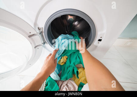 Bunte schmutzige Wäsche im Wäschekorb auf weißem Hintergrund Stockfoto