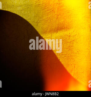 Unscharfer Hintergrund gelb Stoff und gebogenen Schatten. Stockfoto