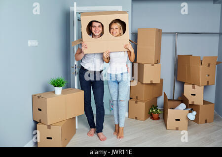 Gerne fröhliche Paare, die in eine neue Wohnung für eine Einweihungsparty teil Stockfoto