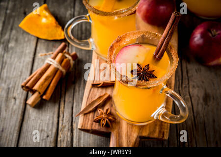 Halloween, Thanksgiving. Traditionelle Herbst, Winter Getränke und Cocktails. Pikanten Kürbis Sangria, mit Apfel, Zimt, Anis. Auf alten Holzmöbeln im Landhausstil Stockfoto