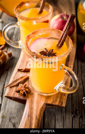 Halloween, Thanksgiving. Traditionelle Herbst, Winter Getränke und Cocktails. Pikanten Kürbis Sangria, mit Apfel, Zimt, Anis. Auf alten Holzmöbeln im Landhausstil Stockfoto