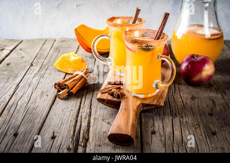 Halloween, Thanksgiving. Traditionelle Herbst, Winter Getränke und Cocktails. Pikanten Kürbis Sangria, mit Apfel, Zimt, Anis. Auf alten Holzmöbeln im Landhausstil Stockfoto