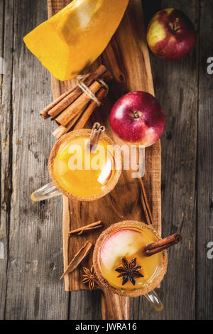 Halloween, Thanksgiving. Traditionelle Herbst, Winter Getränke und Cocktails. Pikanten Kürbis Sangria, mit Apfel, Zimt, Anis. Auf alten Holzmöbeln im Landhausstil Stockfoto