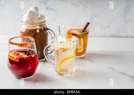 Auswahl von verschiedenen Herbst traditionelle Getränke: heiße Schokolade mit Marshmallows, Tee mit Zitrone und Ingwer, Weiß Kürbis würziger Sangria, Glühwein. O Stockfoto