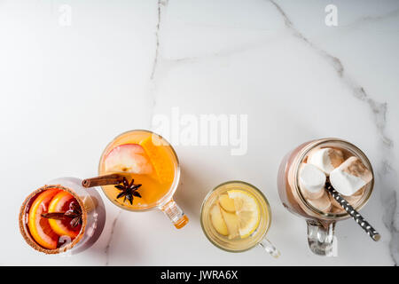 Auswahl von verschiedenen Herbst traditionelle Getränke: heiße Schokolade mit Marshmallows, Tee mit Zitrone und Ingwer, Weiß Kürbis würziger Sangria, Glühwein. O Stockfoto