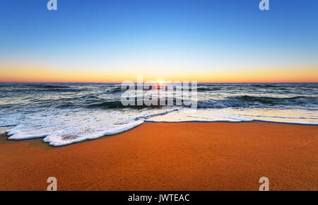 Majestätische Meer Sonnenuntergang mit einer brechenden Welle. Stockfoto