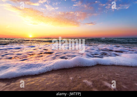 Majestätische Meer Sonnenuntergang mit einer brechenden Welle. Stockfoto