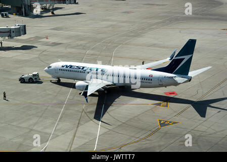 Westjet Airlines Boeing 737-8 CT (w) Airliner C-FUCS wird von einem Schlepper abgeschleppt auf internationalen Flughafen Calgary Alberta Kanada Stand Stockfoto