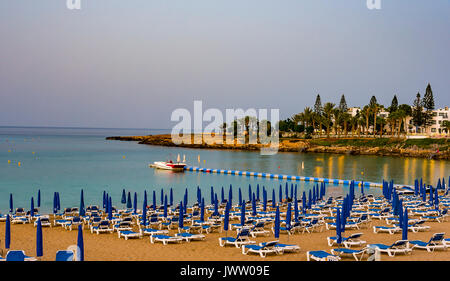 August 2, 2017. Protaras. Liegen mit Sonnenschirmen am Strand von Fig Tree Bay in Protaras Zypern. Fig Tree Beach Zypern Stockfoto