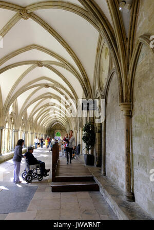 Mann im Rollstuhl mit seinem Betreuer an der behindertengerechte Rampe zum Refektorium und Shop in der Kathedrale von Salisbury, Wiltshire, UK Stockfoto