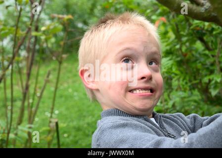 Junge mit Down-syndrom seine Stärke zeigen. Stockfoto