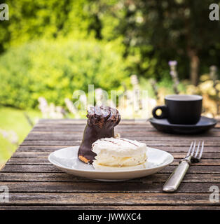Süße Kuchen auf rustikalen Schreibtisch mit Tasse Kaffee im Garten. Stockfoto