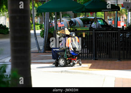 Deaktiviert army Veteran in seinem motorisierten Rollstuhl in der Innenstadt von Sarasota, FL, USA Stockfoto