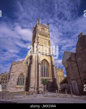 Kirche St. Johannes Baptist Exterieur, Cirencester. Sunlit äußere der historischen Kirche gegen den strahlend blauen Himmel, Cotswolds, Gloucestershire, England, UK. Stockfoto