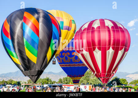 Heißluftballons aufgereiht und bereit am sandigen Balloon Festival zu starten. Stockfoto