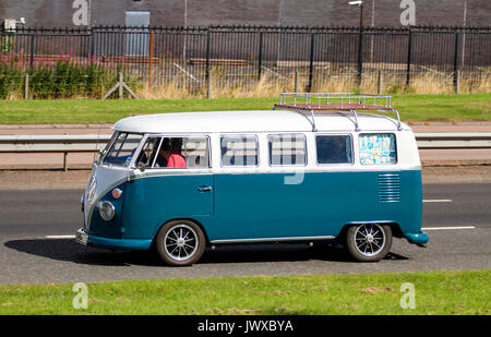 Ein junges Paar und ihrem Hund genießen Sie einen Tag in Ihre 1967 VW Camper van entlang der Kingsway West zweispurigen Straße in Dundee, Großbritannien Stockfoto