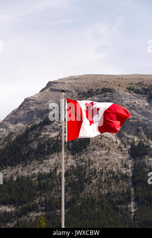 Der kanadische Maple Leaf Flag fliegt hoch von einem Fahnenmast über Banff in Alberta, Kanada Stockfoto