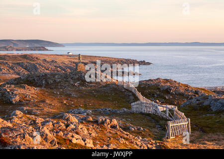 Eine felsige Küste bei Sonnenuntergang mit der John Cabot Statue in der Ferne. John Cabot städtischen Park, Bonavista Peninsula, Bonavista, Neufundland. Stockfoto