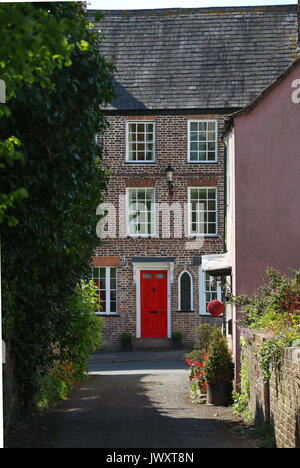 Alte 3-stöckige Haus auf der Hohe Straße in der Nähe von Berkeley Castle, Berkeley, Gloucestershire, UK mit einem hellen roten Tür, Prost auf die Straße. Stockfoto