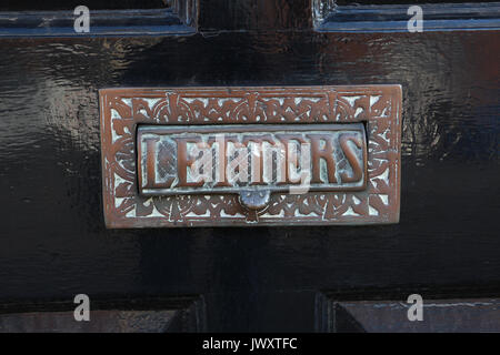 Altmodische Bronze schreiben Steckplatz auf der schwarzen Front Tür eines englischen Haus, mit einer Kante Muster und das Wort 'Buchstaben' auf die Steckplatzabdeckung eingeschrieben. Stockfoto