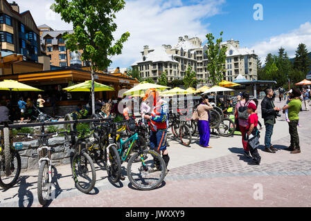 Mountainbiker bunte Kleidung Entspannung in Restaurants und Bars in Whistler Resort Stadt British Columbia Kanada Stockfoto