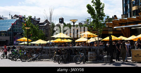 Mountainbiker bunte Kleidung Entspannung in Restaurants und Bars in Whistler Resort Stadt British Columbia Kanada Stockfoto