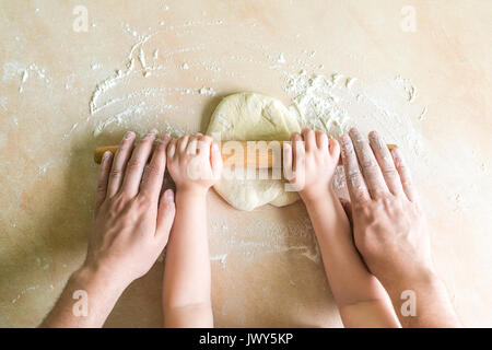 Kinder und Papa Händen Teig gerollt Stockfoto