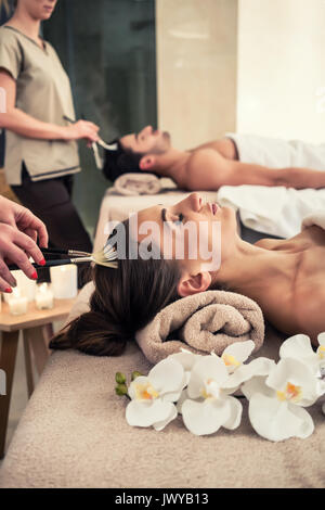 Entspannt Frau liegend auf Bett während der Massage Gesichtsbehandlung Stockfoto