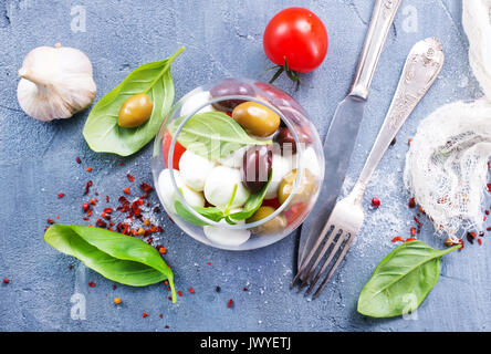 Caprese Salat in Glasschale und auf einem Tisch Stockfoto