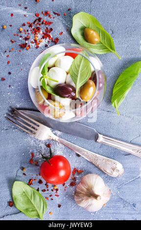 Caprese Salat in Glasschale und auf einem Tisch Stockfoto