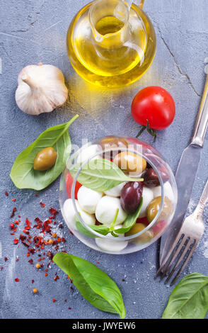 Caprese Salat in Glasschale und auf einem Tisch Stockfoto