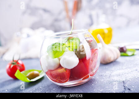 Caprese Salat in Glasschale und auf einem Tisch Stockfoto