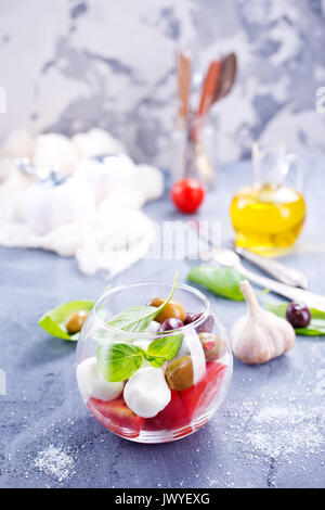 Caprese Salat in Glasschale und auf einem Tisch Stockfoto