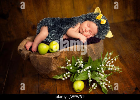 Lustige neugeborenes Baby Mädchen in einem Kostüm von Igel schlafen süß auf den Stumpf Stockfoto