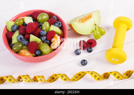 Obstsalat, Maßband und Hanteln für den Einsatz in Fitness, Sport, Ernährung, gesunde Lebensführung und Ernährung Stockfoto